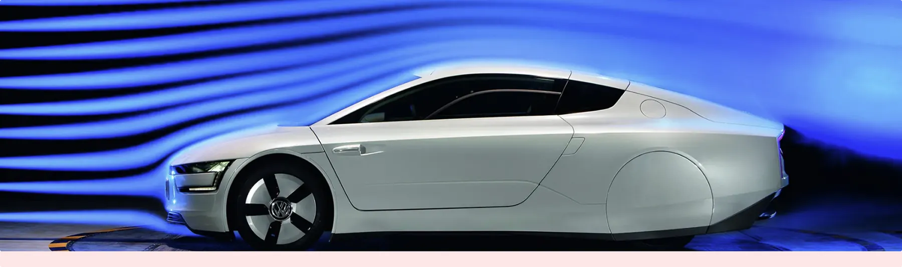 Volkswagen XL1 in a wind tunnel, with smoke streamlines following its long tapered rear