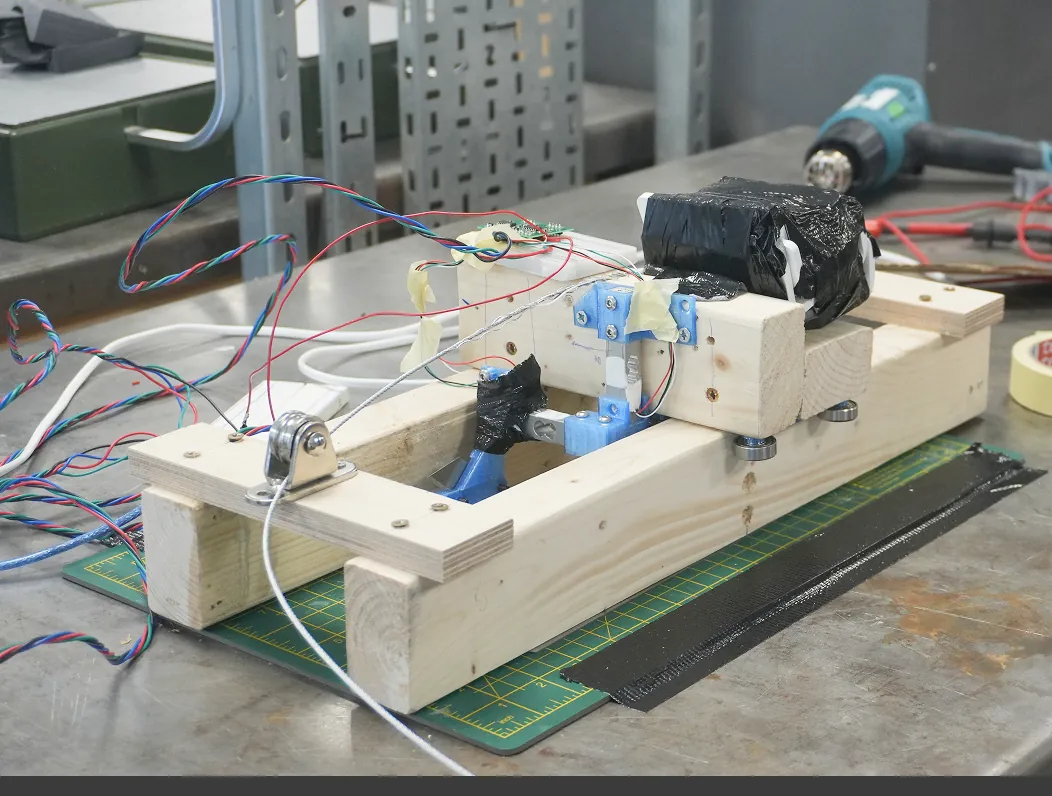 Wooden drag test rig with a pulley, load cell wiring and the 3D-printed blade mount