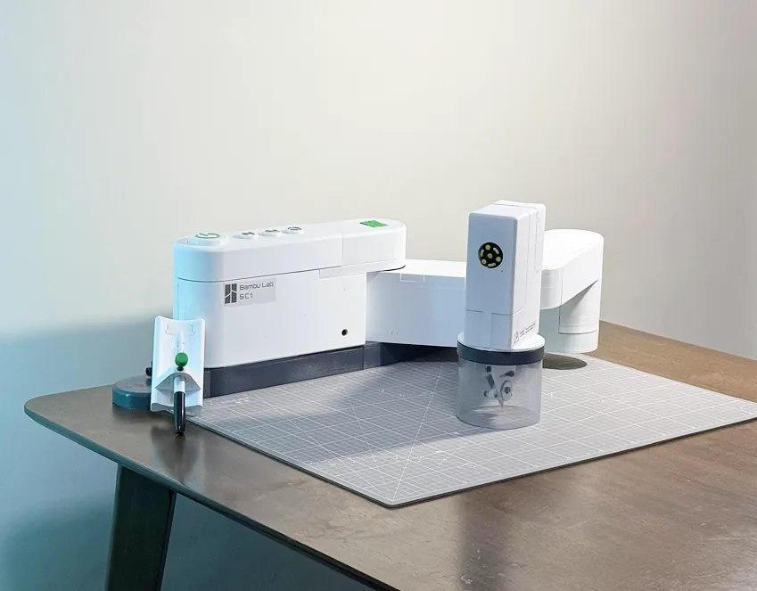 The SwivelCut SC1 prototype on a cutting mat, with its tracing head and cone-guarded cutting head
